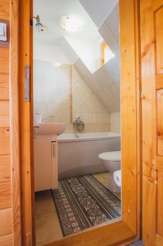 a bathroom with a tub and a toilet and a sink at Casa de vacanta ROUA DIMINETII in Beclean