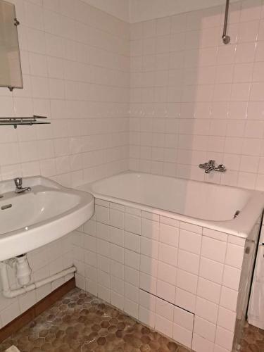 une salle de bain blanche avec une baignoire et un lavabo dans l'établissement Les gites flora la lavande et châtaignier, à Barnas