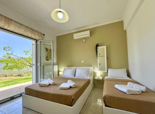 two beds in a room with a window at Villa Serenity Spilia Garden floor in Argostoli