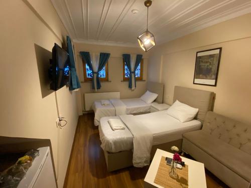 - un salon avec deux lits et un canapé dans l'établissement Akaretler Vera Suites, à Istanbul
