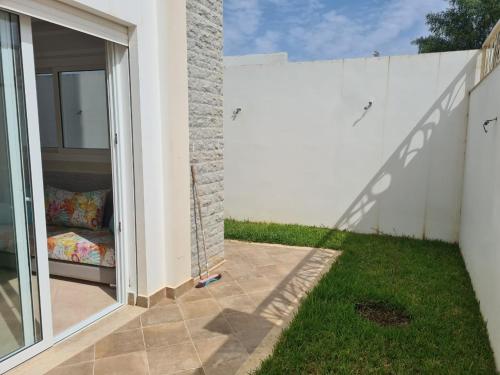 a backyard with a white fence and grass at Appartements Horizon in M'diq