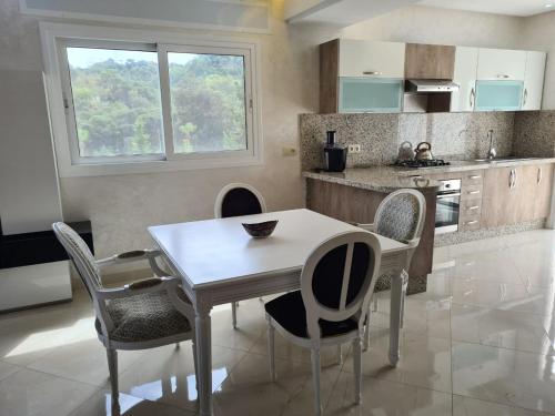 a kitchen with a dining room table and chairs at Appartements Horizon in M'diq