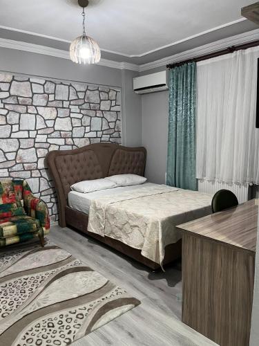 a bedroom with a bed and a stone wall at YALı APART HOTEL in Trabzon