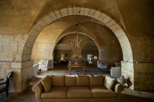 a living room with a couch in a stone building at Castello Camemi in Vizzini