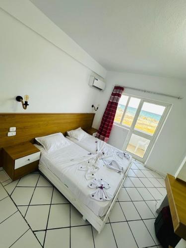 a bedroom with a bed with a table and a window at Hotel Best Beach- Family Only in Chott Meriem