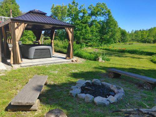 a backyard with a gazebo and a fire pit at The Nest in the Forest Bed and Breakfast (Hot tub and Sauna) in Lakefield