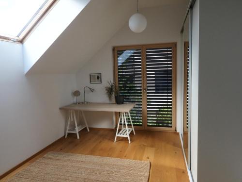 an attic room with a desk and a window at Hiša Eva in Bizovik