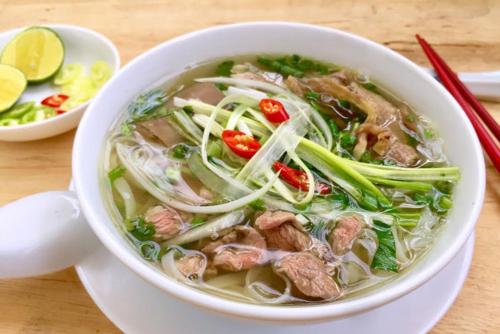 a bowl of soup with meat and vegetables on a table at Clover Home Quảng Bình in Dong Hoi