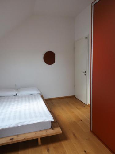 a white bedroom with a bed and a door at Hiša Eva in Bizovik
