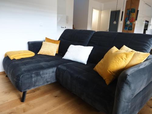 a black leather couch with yellow pillows on it at Hiša Eva in Bizovik