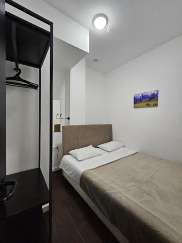 a bedroom with a bed in a white room at Sulu Hostel in Astana