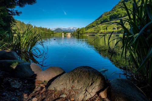 a view of a lake with rocks in the foreground at Residence Hotel Miralago in Pergine Valsugana