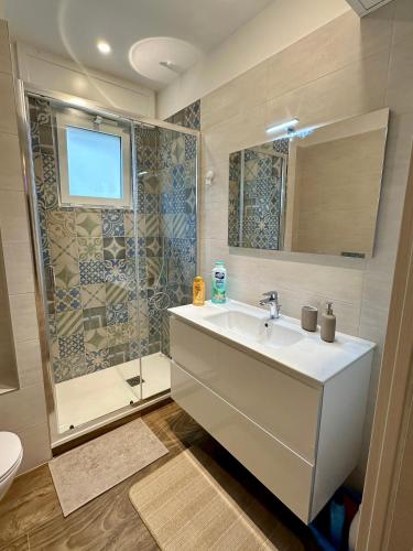 a bathroom with a sink and a shower at Rainbow Luxury Home Bari in Bari