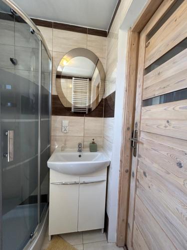 a bathroom with a sink and a mirror at Agroturystyka u Basi i Waldka in Zelwa
