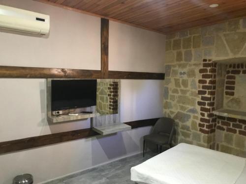 Zimmer mit einem Tisch und einem TV an der Wand in der Unterkunft SunAnatolia Otel in Antalya