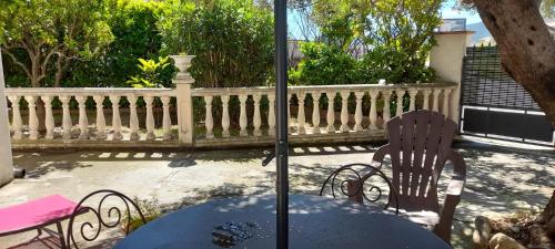 un patio avec une table et des chaises et une clôture dans l'établissement Charmant appartement de vacances, à Argelès-sur-Mer