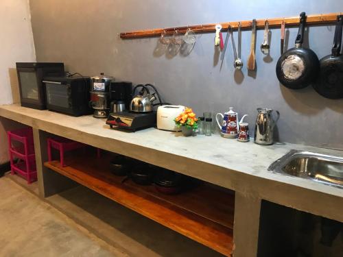 a kitchen with a counter top with a sink and utensils at yoshen Villa in Unawatuna