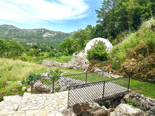 a set of stairs leading to a garden with mountains in the background at ZEN Relaxing Village in Cetinje