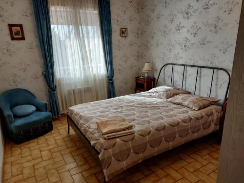 une chambre avec un lit et une chaise bleue dans l'établissement villa spacieuse avec piscine, à La Crau