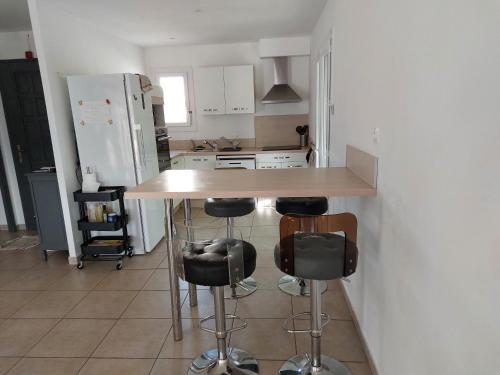 - une cuisine avec un comptoir et des tabourets dans l'établissement villa spacieuse avec piscine, à La Crau