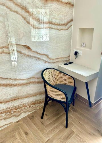 a chair next to a desk and a sink at Aesthesis Arxontiko Luxury Rooms in Mirina