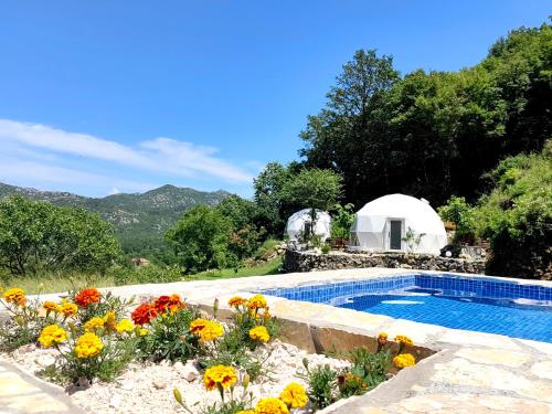a swimming pool with flowers in front of a white dome at ZEN Relaxing Village in Cetinje