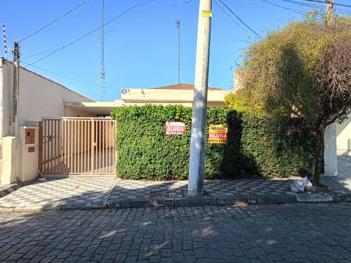 a pole in front of a building with a hedge at Casa inteira no Centro de Jacareí próximo à São José dos Campos in Jacareí