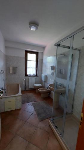 a bathroom with a tub and two toilets and a shower at Cascina della Chiesa in Ponzone