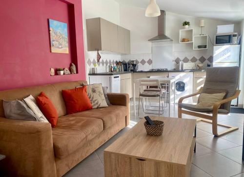 a living room with a couch and a table at Logement calme et chaleureux dans villa in Évenos