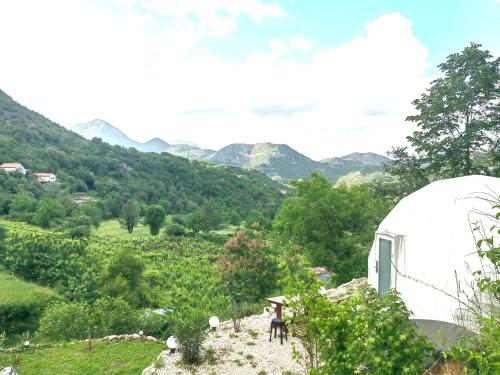 a person riding a horse in a field with mountains in the background at ZEN Relaxing Village in Cetinje