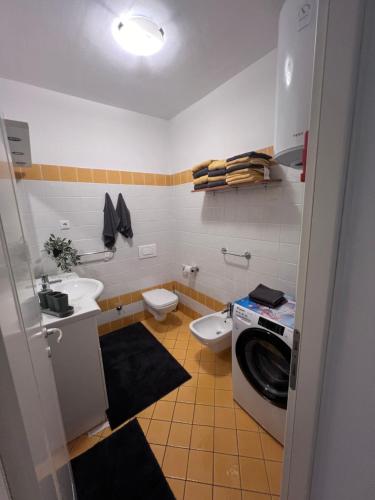 ein Badezimmer mit einem Waschbecken und einer Waschmaschine in der Unterkunft Jovì`s Apartment in Tar