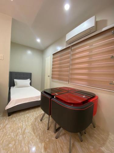 a bedroom with a bed and a red desk at Prime Lodge Hotel in Romblon