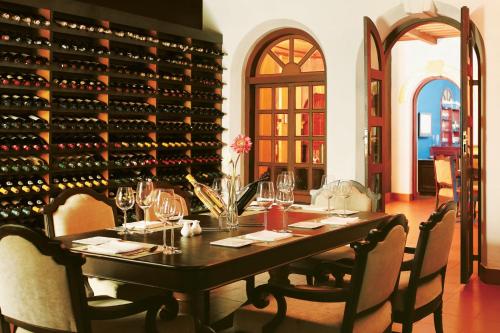 a dining room with a table and a wall of wine bottles at Taj Kumarakom Resort and Spa Kerala in Kumarakom
