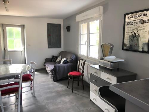 un salon avec un canapé et une table dans l'établissement petite maison, à La Haye-dʼEctot