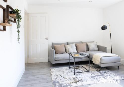 un salon avec un canapé et une table dans l'établissement One Bedroom Apartment At Smooth Stays Short Lets & Serviced Accommodation Preston With Parking Near Train Station, à Preston