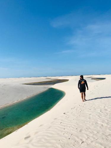 um homem andando em uma praia perto da água em Recanto Sapoti em Barreirinhas