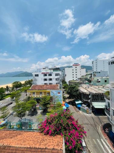 a view of a city with pink flowers and buildings at Wow Hotel Quy Nhon in Quy Nhon