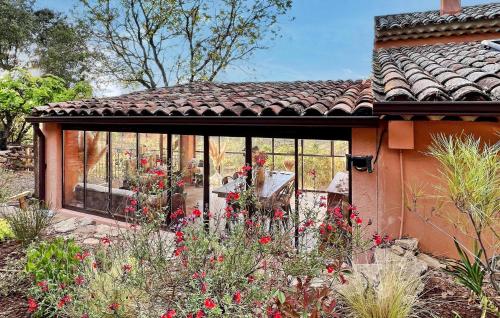 un jardin avec des fleurs rouges en face d'une maison dans l'établissement Lou Cabe Roma, à Carcès