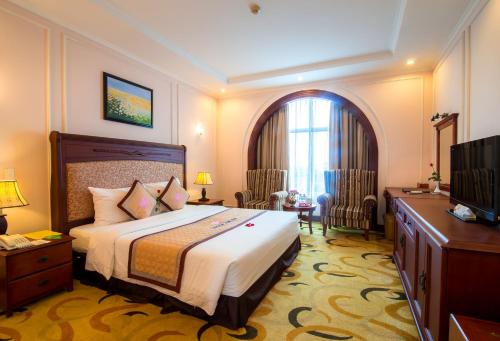 a hotel room with a bed and a television at Sai Gon Kim Lien Hotel Vinh City in Vinh