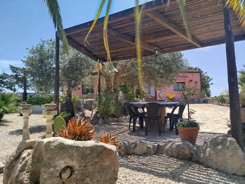 a patio with a table and chairs under a pergola at Villa Virginia in Ragusa