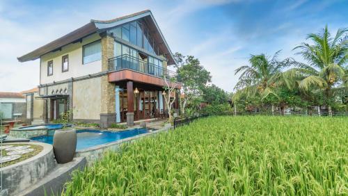 a house with a rice field in front of it at Maruan Sari in Ubud