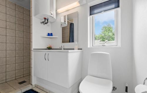 baño blanco con aseo y ventana en 2 Bedroom Lovely Home In Sams en Onsbjerg