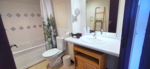 une salle de bain avec un lavabo blanc et des toilettes dans l'établissement O'TINY Suite familiale 4 personnes, gare, centre ville, sanctuaire, à Lourdes