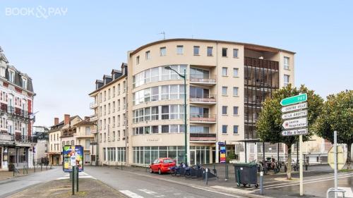 - un grand bâtiment sur une rue de la ville avec des panneaux de signalisation dans l'établissement O'TINY Suite familiale 4 personnes, gare, centre ville, sanctuaire, à Lourdes