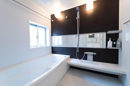 a bathroom with a bath tub and a shower at サテライトホテル恵比寿 Satellite Hotel Ebisu in Tokyo