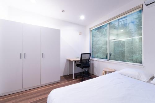 a bedroom with a bed and a desk and a window at サテライトホテル恵比寿 Satellite Hotel Ebisu in Tokyo