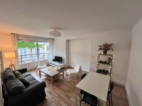 un salon avec un canapé et une table dans l'établissement Hyper Centre - À Proximité des maisons de champagne, à Reims