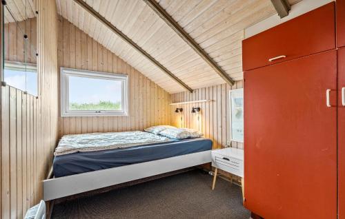 スナーヴィグにある3 Bedroom Stunning Home In Ringkbingのベッド付きの小さな家のベッドルーム1室