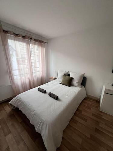 - une chambre dotée d'un grand lit blanc avec deux chaussures dans l'établissement Hyper Centre - À Proximité des maisons de champagne, à Reims