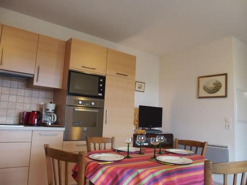 une cuisine avec une table avec des assiettes et des verres à vin dans l'établissement Pour un séjour au calme entre océan et montagne, à Ustaritz